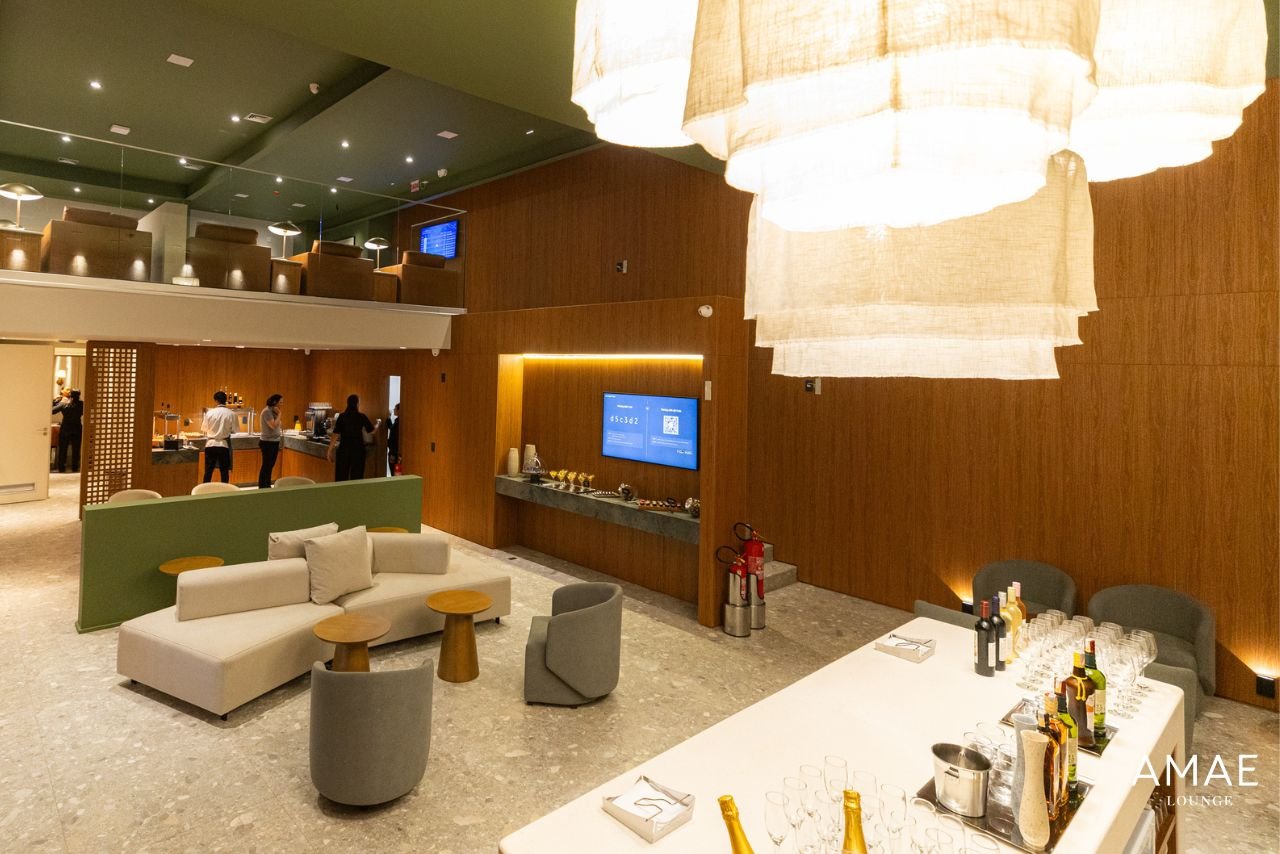 Vista do AMAE Lounge no Aeroporto de Florianópolis, com sofás e área de alimentação