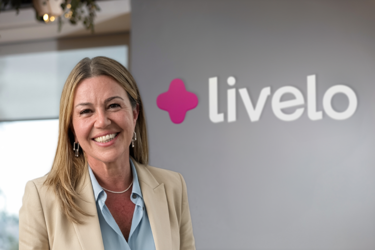 Carla Nesi, nova CEO da Livelo, diante da logomarca da companhia